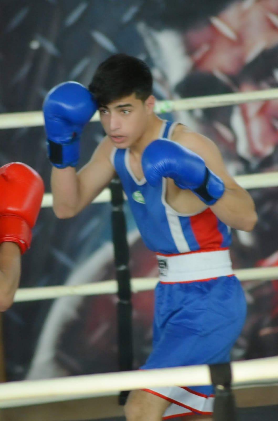 Boxer in blue keeping his guard up mid-round
